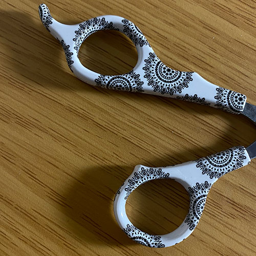 close up hair scissor handle image with a flower print over the handle