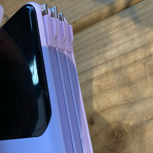 purple power bank side view. The cable storage hub showing